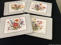 Group photo of all four rectangular table mats featuring North American wild flowers with beige borders on black background.