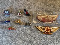 Overview of 10 assorted Canadian air travel pins on a grey background.
