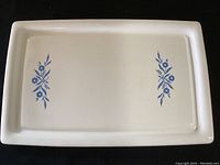 Top view of rectangular white ceramic Corning Ware baking tray with blue floral designs on the inside surface.