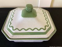 Top view of square mid century casserole with green and white enamel and a raised green knob.