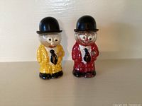 Front view of the pair of Moon Mullins salt and pepper shakers showing the yellow and red suits and painted faces.