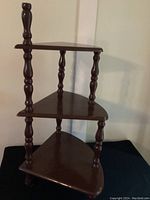 Front angle showing full three-tiered hardwood stand with turned legs and triangular shelves