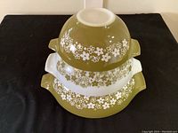 Stacked view of 3 Pyrex Spring Blossom Cinderella nesting bowls showing olive green, white and floral design