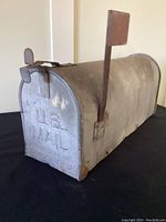 Front angled view showing mailbox with raised U.S. MAIL text and latch closure.