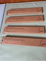 Photo showing four unopened brown cardboard boxes of PF Candle Co lavender incense sticks laid on a wooden surface.