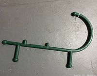 Photo shows a green plastic self-massager tool with a hook handle and multiple rounded knobs spaced along its length for back massage.