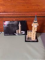 Photo showing assembled Big Ben Lego Architecture model on a table with the original instruction manual beside it.