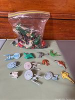 Star Trek Micro Machines miniature spaceships displayed in front of a clear plastic bag of LEGO pieces on a wooden surface.