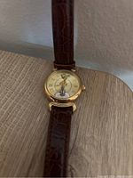 Close-up of the Tweety Bird watch face showing the gold-tone case, Roman numeral markers, and Tweety Bird image with watch hands designed as Tweety's arms.