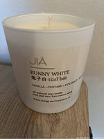 Photo of JIA Bunny White soy candle in white glass container with label showing scent details and size.