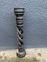 Front view of large outdoor candle holder showing twisted design and ornate bowl holder.