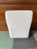 Front view of the portable Ready Rocker seat rocker showing the white cushioned lumbar back support with mesh-like fabric texture and smooth lower panel.