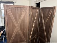 Two wooden privacy screens connected, showing front and side angles