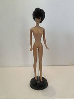 Brunette Bubblecut Barbie doll full view on black circular stand