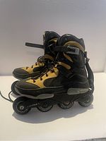 Side view of men's size 10.5 black and tan detachable inline rollerblade showing wheels and frame with light wear.