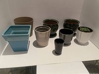 Overview of the 9 miscellaneous plant pots on a white surface.