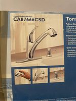 Box showing Moen CA87666CSD model number with image of chrome finish kitchen faucet with pullout spray, single handle, and base plate.