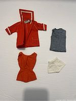 Red jacket, striped top, swimsuit, and socks shown flat on a white background