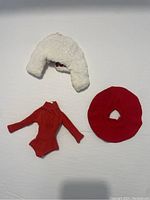 White faux fur jacket, red bodysuit, and red circular neck accessory laid flat on a white background.