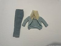 Front view of vintage Barbie outfit including light blue corduroy pants and knit sweater with cream turtleneck.