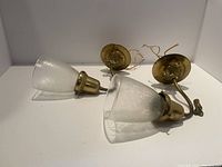 Pair of vintage brass wall sconces with frosted etched glass shades showing floral and geometric patterns