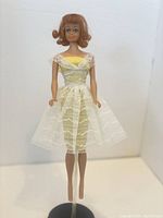 Front full body view of Vintage Midge doll wearing white lace dress over yellow underdress, missing some hair on side.