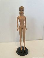 Front view of the nude vintage Swirl Barbie doll on a plastic display stand.