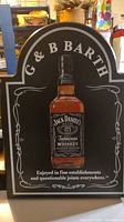 Front facing view of the black and white wooden wall plaque featuring Jack Daniels Tennessee Whiskey bottle graphic and labeled G & B BARTH.