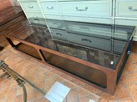 Angled top-down view of coffee table showing wood frame and smoked glass top