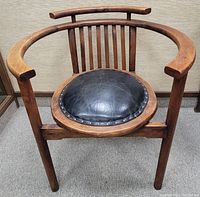 Front view showing full horseshoe-shaped frame and round leather seat