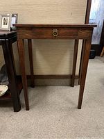 Front view of vintage wood hall table showing drawer with brass ring pull handle.