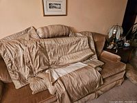Brown duvet set including duvet cover draped over chair, matching pillow shams and bolster pillow cover