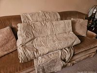 Photo showing beige slightly used duvet cover and matching pillowcases laid out on couch, fabric has floral embroidery and needs cleaning as per seller.