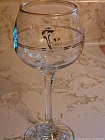 Single wine glass showing Petro Canada Olympic logo and gold rim detail.