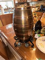 Front view of copper cask on iron stand with hanging cups