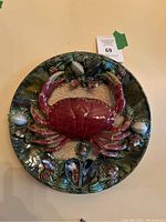 Front view of circular ceramic plate with central red crab and marine motifs