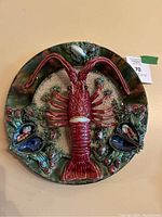 Front view showing red relief lobster and surrounding seashell motifs