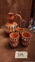 Full view of vintage Bulgarian pottery set with jug and four cups showing painted detail and finish.
