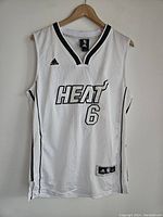 Front view of white Miami Heat jersey with number 6 and team name in black, Adidas logo visible