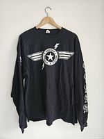 Full view of black long-sleeve Motorhead sweatshirt showing front logo design with white star emblem and lightning bolt wings.