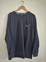 Full front view of navy blue long sleeve sweatshirt on hanger