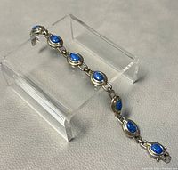 Full view of the 7.5 inch bracelet showing seven oval lapis lazuli stones set in sterling silver links with a safety clasp.