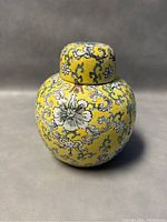 Front view of the Chinese yellow floral embossed ginger jar with lid, showing detailed embossing and color pattern.