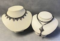 Both old sterling silver necklace and choker displayed on white necklace stands showing overall condition, design, and length.