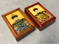 Pair of small wooden boxes with glass fronts showing colorful reverse hand painted portraits of Qing Dynasty empresses in traditional robes and headdresses.
