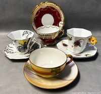 Four bone china teacup and saucer sets displayed together showing various designs, shapes, and colors.