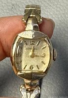 Front view of watch showing dial with Longines branding, gold-tone indices, and worn crystal with light scratches.