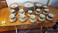 Complete set of dinnerware including plates, cups, and saucers arranged on table.