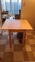 Full view of laminate kitchenette table with pull-out leafs extended.