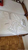 Full view of white linen shirt, apron, and packaged table runner on bed